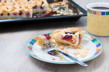 Plum cake and cup of coffee on wooden table