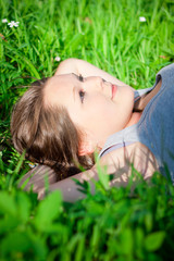 Closeup of a young girl relaxing and lying in grass