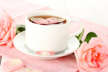 cup of tea with roses on white wooden table