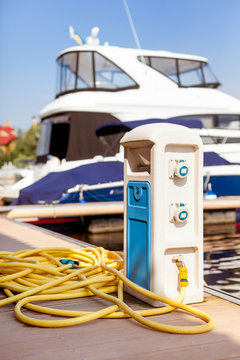 Boat and water supply. A boat on a dock and a water supply.