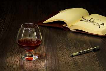 Cognac, cigar and an old book nearby