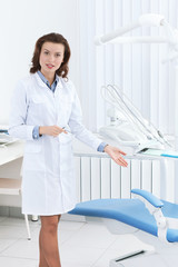 Beautiful doctor's assistant shows the dentist's chair