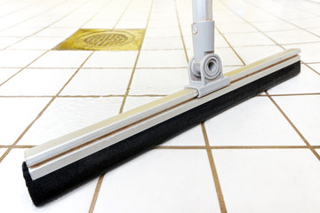 Cleaning tiled bathroom with floor wiper