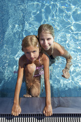 Woman with girl swimming in pool