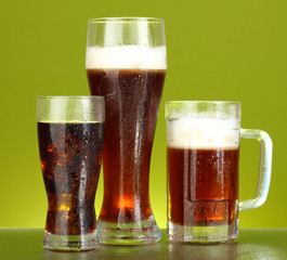 refreshments - beer, cola and kvass on green background