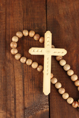 the Wooden rosary beads on wooden background close-up