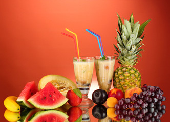 Milk shakes with fruit on red background close-up
