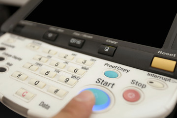 Finger pressing of keyboard buttons of the laser copier