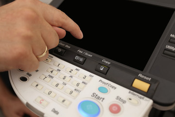 Finger pressing of keyboard buttons of the laser copier