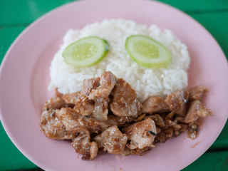 rice and fried pork with garlic on white plate