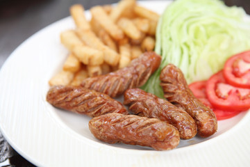 Sausage with potato on wood background