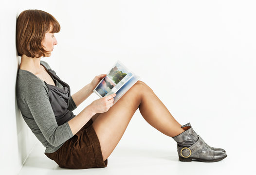 Woman sitting on the floor with book