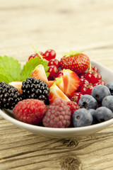 gemischte früchte und beeren in einer schale als nachtisch auf