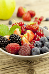 gemischte früchte und beeren in einer schale als nachtisch auf