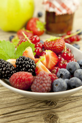 gemischte früchte und beeren in einer schale als nachtisch auf