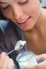 young woman at home eating yogurt