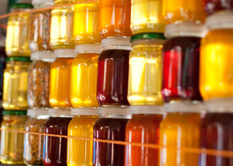 Glass jars with honey background