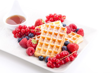 Frische süße Waffeln mit Puderzucker und beeren auf einem Tell