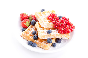 Frische süße Waffeln mit Puderzucker und beeren auf einem Tell