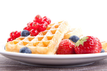 Frische süße Waffeln mit Puderzucker und beeren auf einem Tell