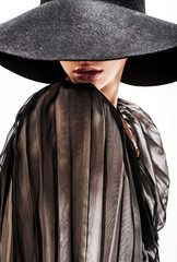 girl in black hat touching face and lips