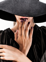 girl in black hat touching face and lips