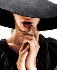 girl in black hat touching face and lips