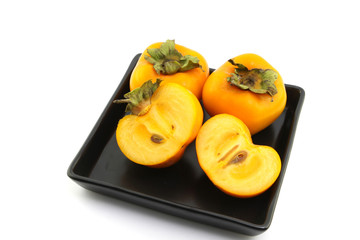 persimmon fruits on dish color black