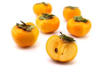 Half of persimmon fruits on white background