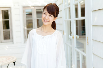 Beautiful young woman standing on terrace. Portrait of asian.
