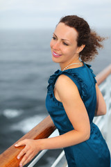 Beautiful woman stands on board of large ship