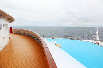 Obraz na płótnie Canvas Pysk z poręczą dużego statku wycieczkowym. Widok z drewnianym tarasem.