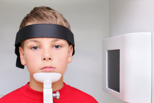 Little serious boy prepared to jaw x-ray image in dental clinic