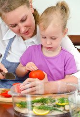 Mother and daughter preparing food in steamer.