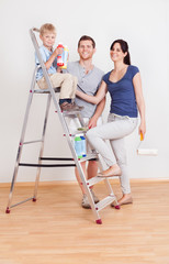 Young couple painting wall at home