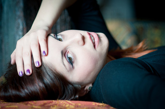 Portrait of a sensual young woman lying on sofa. 