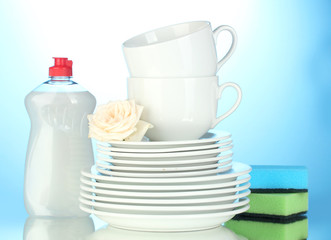 empty clean plates and cups with dishwashing liquid and sponges