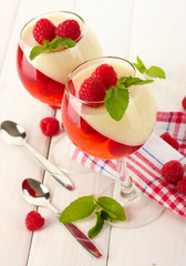 fruit jelly with raspberries in glasses on wooden table