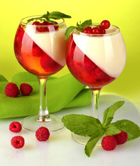 fruit jelly with berries in glasses on green background