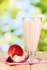 Peach milk shake on wooden table on bright background