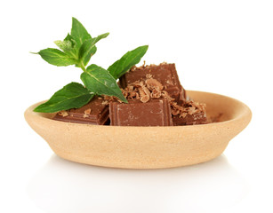 Pieces of chocolate and mint on the clay plate isolated on