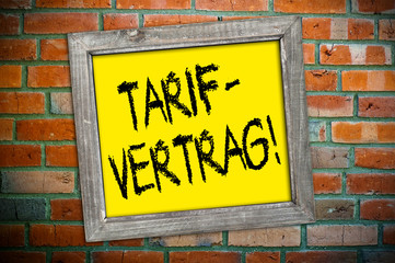 Ziegelsteinmauer mit Schild und Tarifvertrag