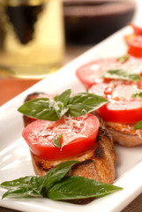 Bruschetta with tomato, mozzarella and basil with a glass of win