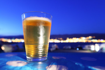 Beer glass chilled at sunset overlooking city lights