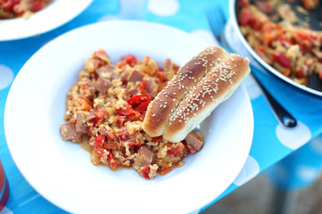 Fried tomatoes and egg dish with sesame bread sticks