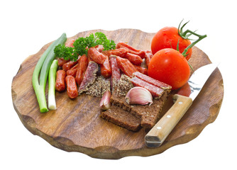 assortment of salami and vegetables on a cutting board