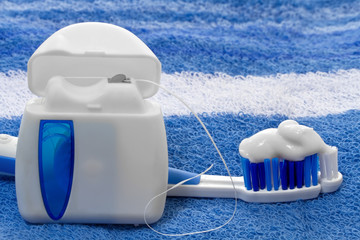 dental floss and toothbrush on a towel