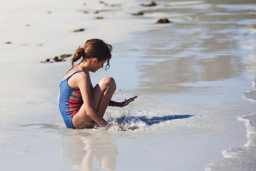 junges Mädchen planscht im Wasser