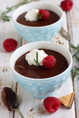 Chocolate and rosemary mousse with whipped cream and raspberry
