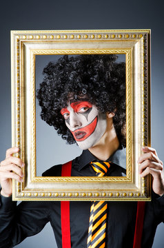 Clown with picture frames in studio